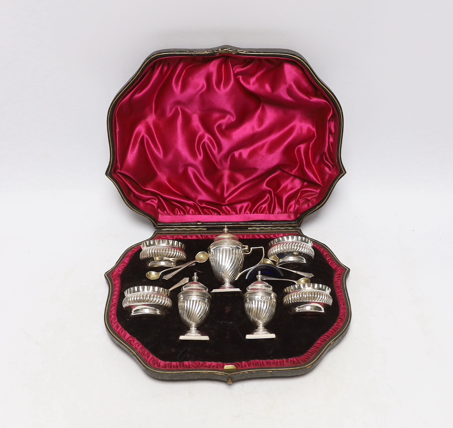 A cased late Victorian seven piece silver condiment set, Josiah Williams & Co Ltd, London, 1898, with five matching spoons.